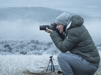 homme photographiant un paysage enneigé